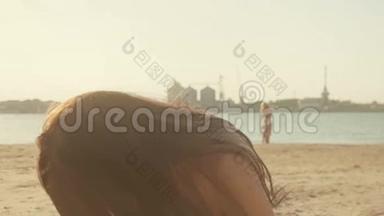 无忧无虑的女人在海滩上的日落中玩得很开心。 度假旅游，活力健康的生活理念.. 她觉得
